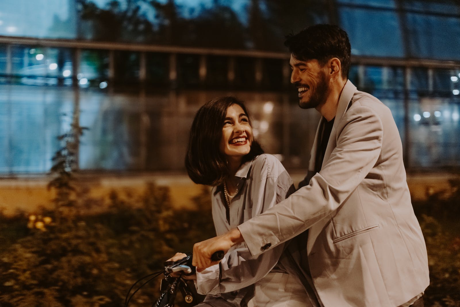 Photo of a Couple Looking at Each Other while Riding a Bicycle