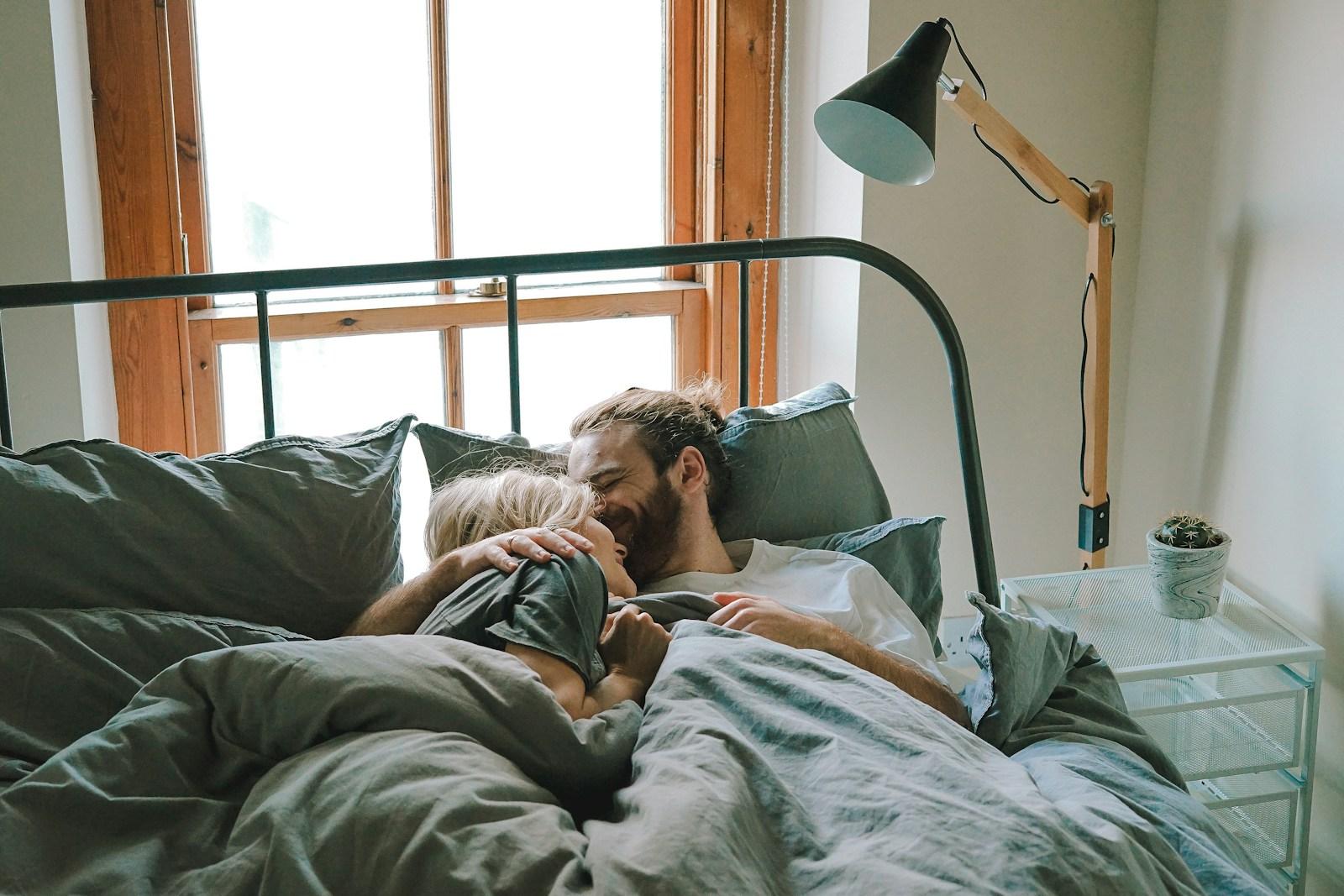 man kissing woman on her forehead