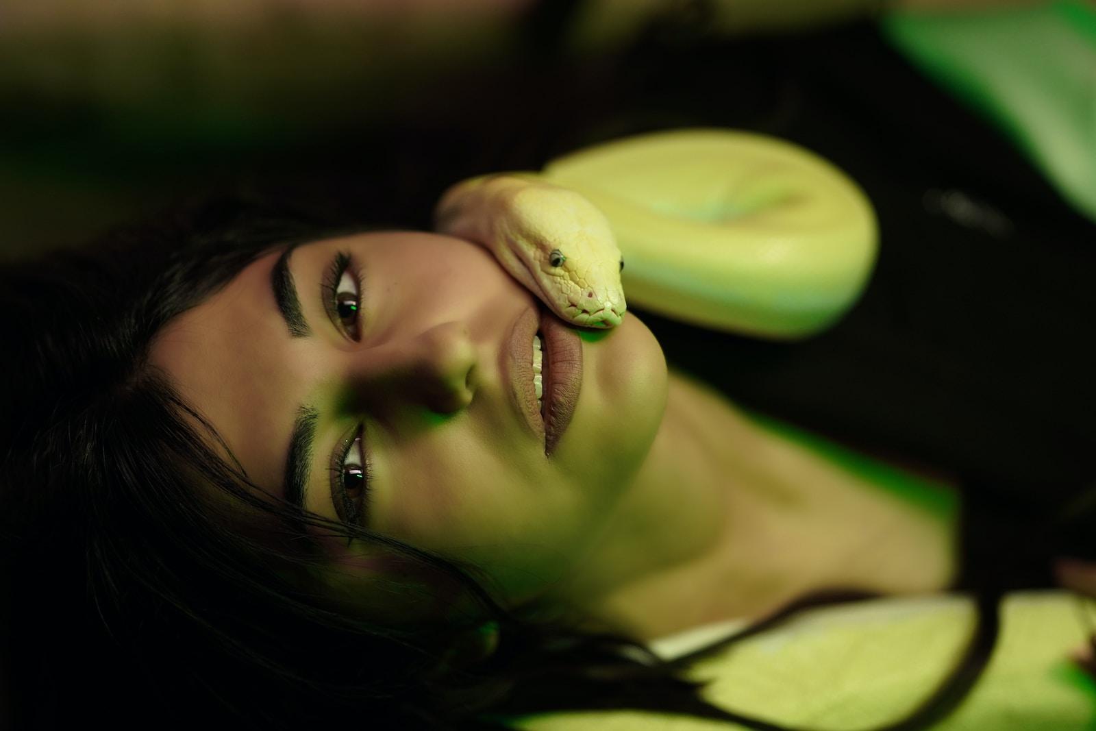 a woman holding a green snake in her hand