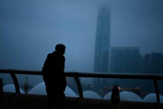 a man standing on top of a bridge next to a tall building