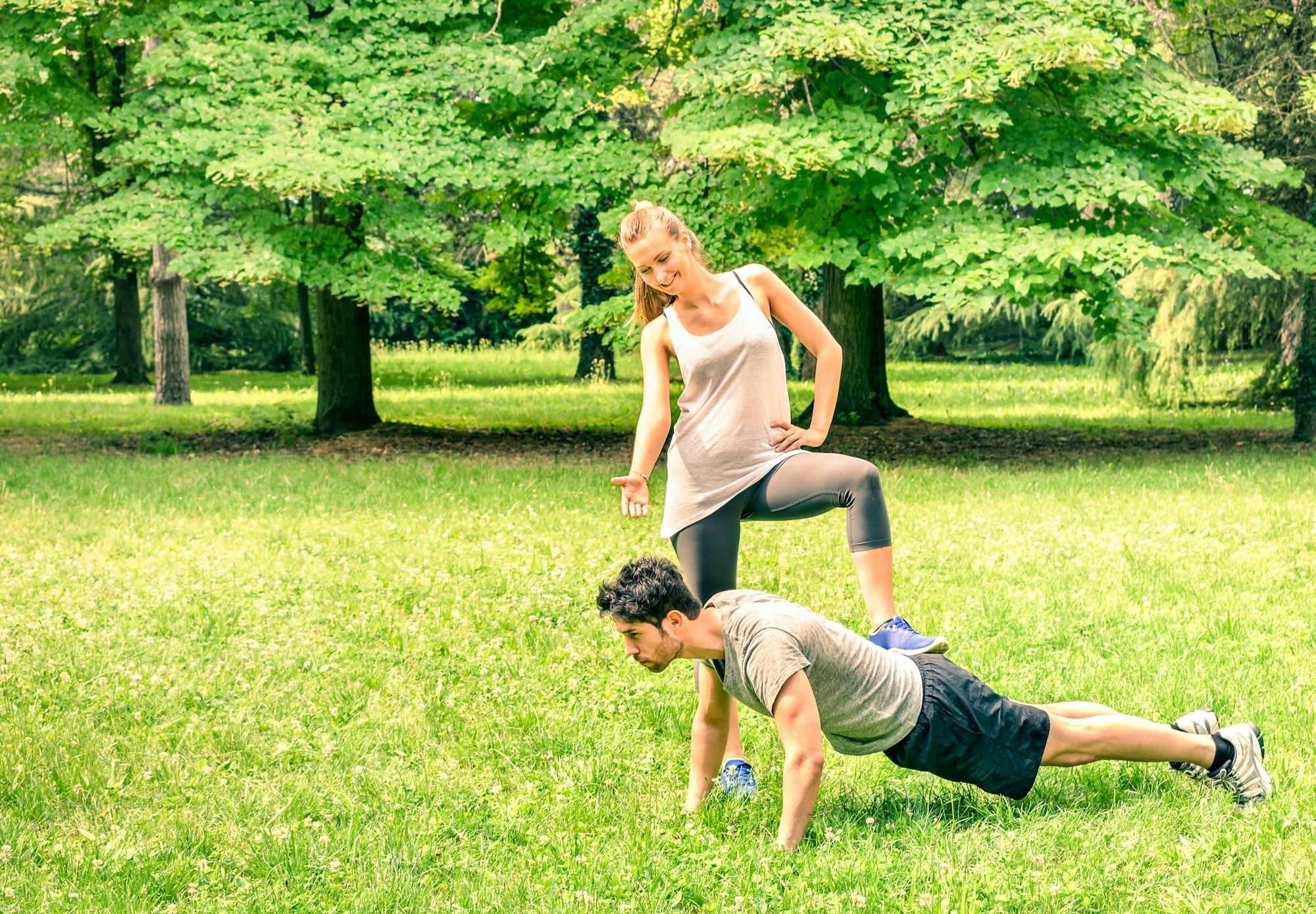 Girlfriend mocking her boyfriend while training in the park