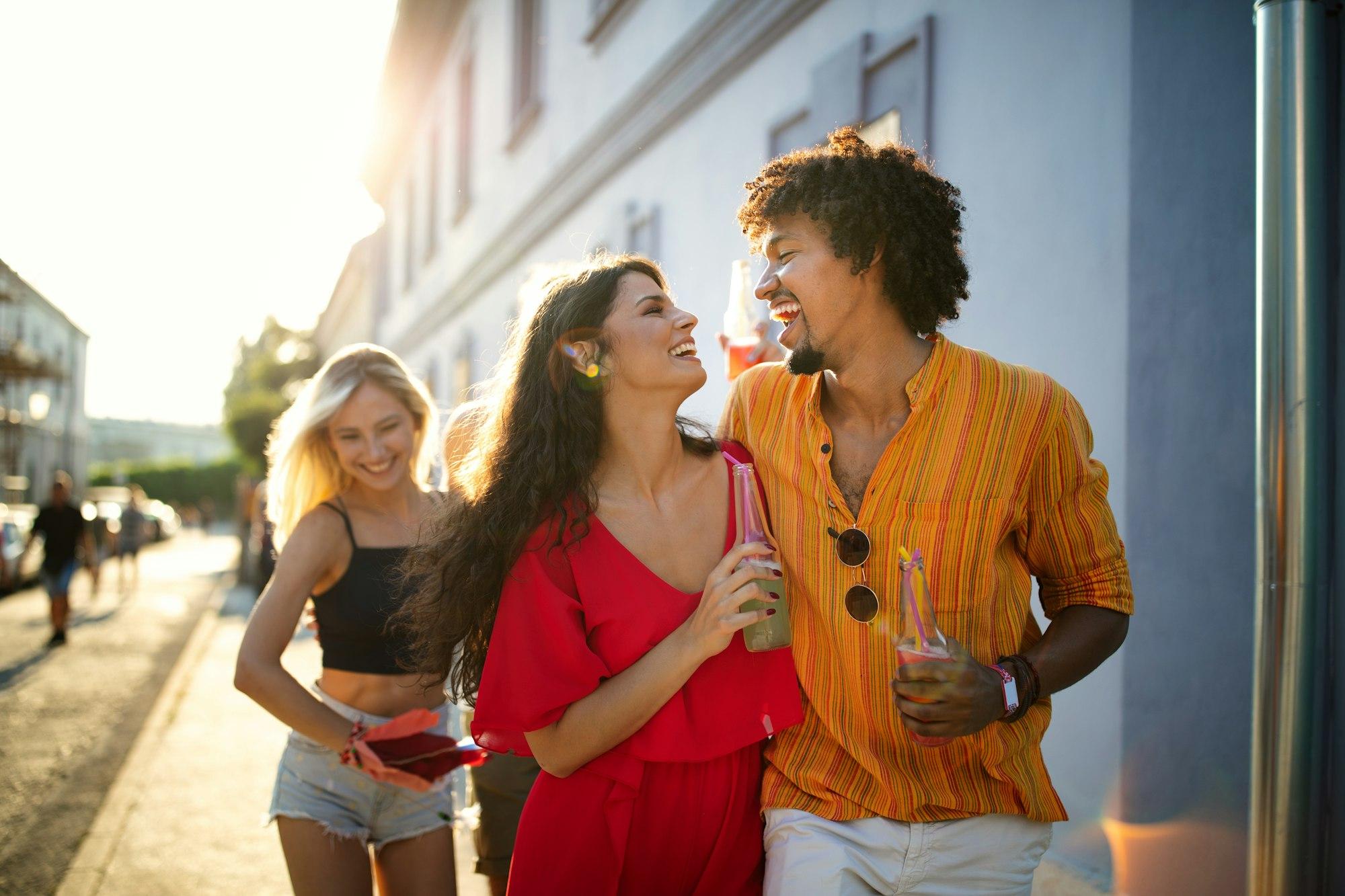 Happy couple, friends having fun together and drinking in the city