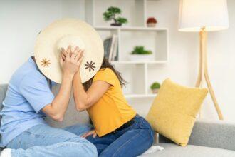 Playful couple kissing sitting on the sofa