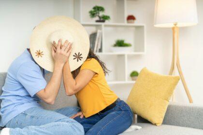 Playful couple kissing sitting on the sofa