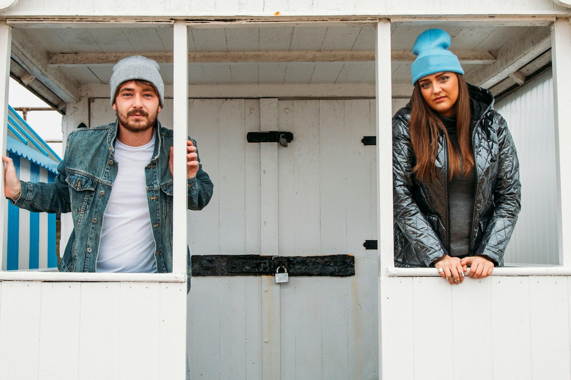 young adult couple, friends, in beach hut together at the seaside beach