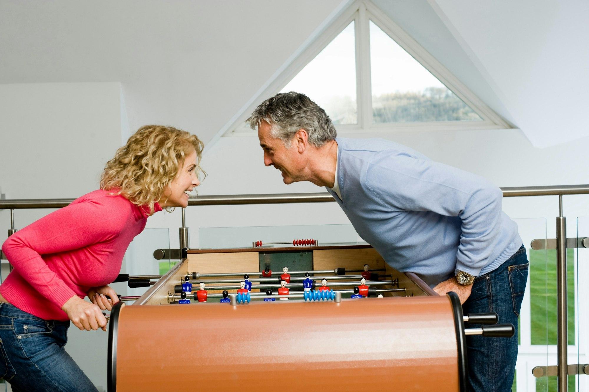 Couple having fun playing table football