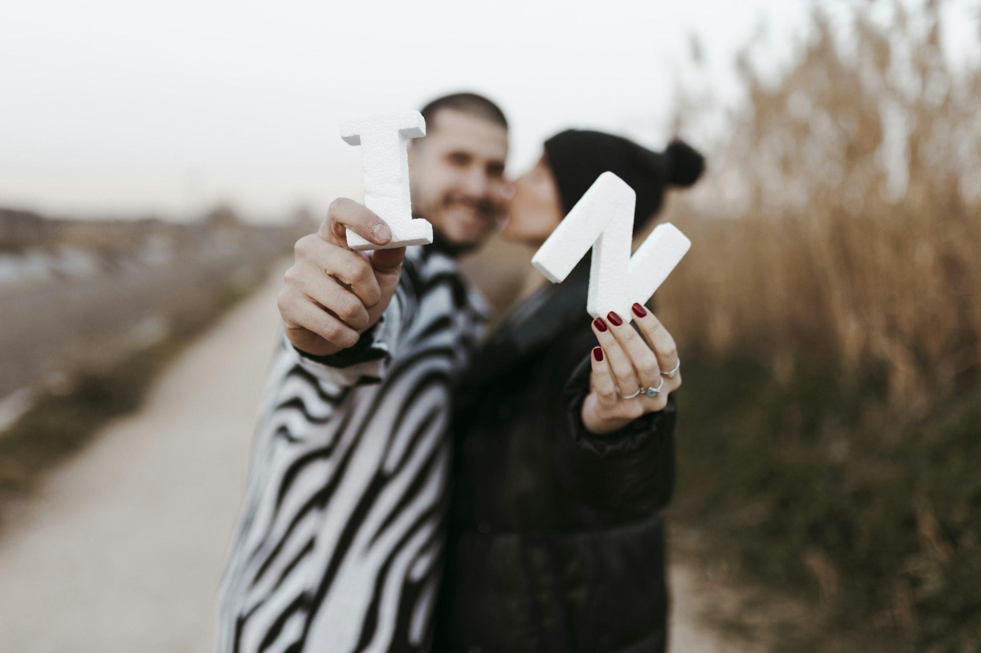 couple showing their initials. Engaged bride and groom