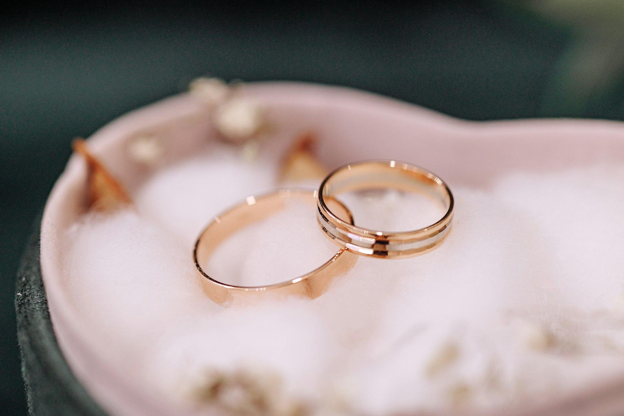 Golden wedding rings in heart-shaped box.