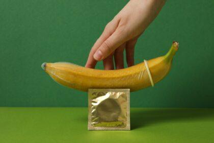 A condom on a banana on a green background