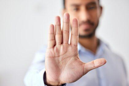 Closeup of the hand of a business man showing stop, saying no or not accepting a deal in an office