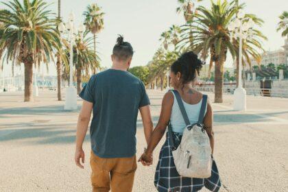 Interracial couple walks down the street holding hands