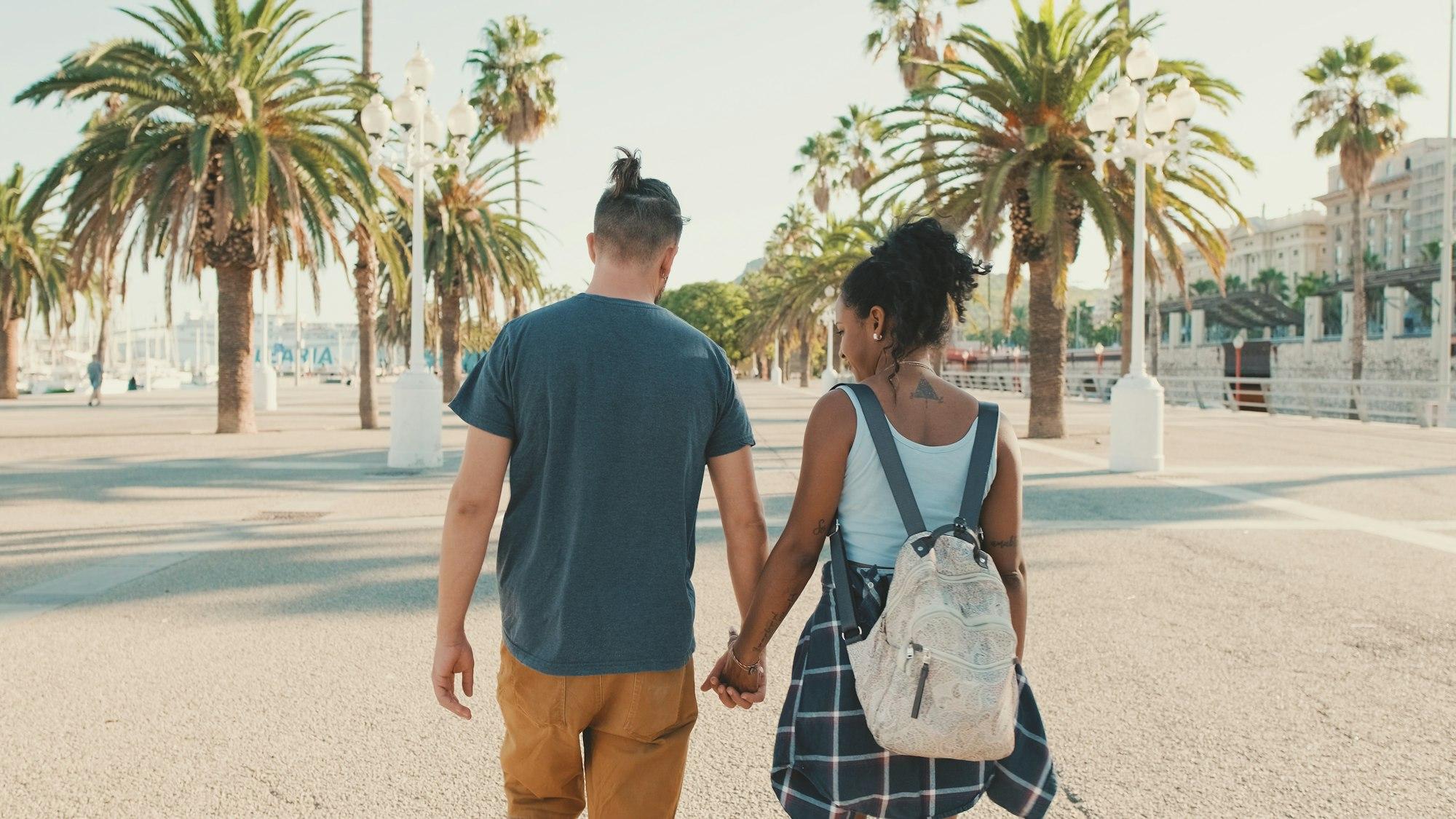 Interracial couple walks down the street holding hands