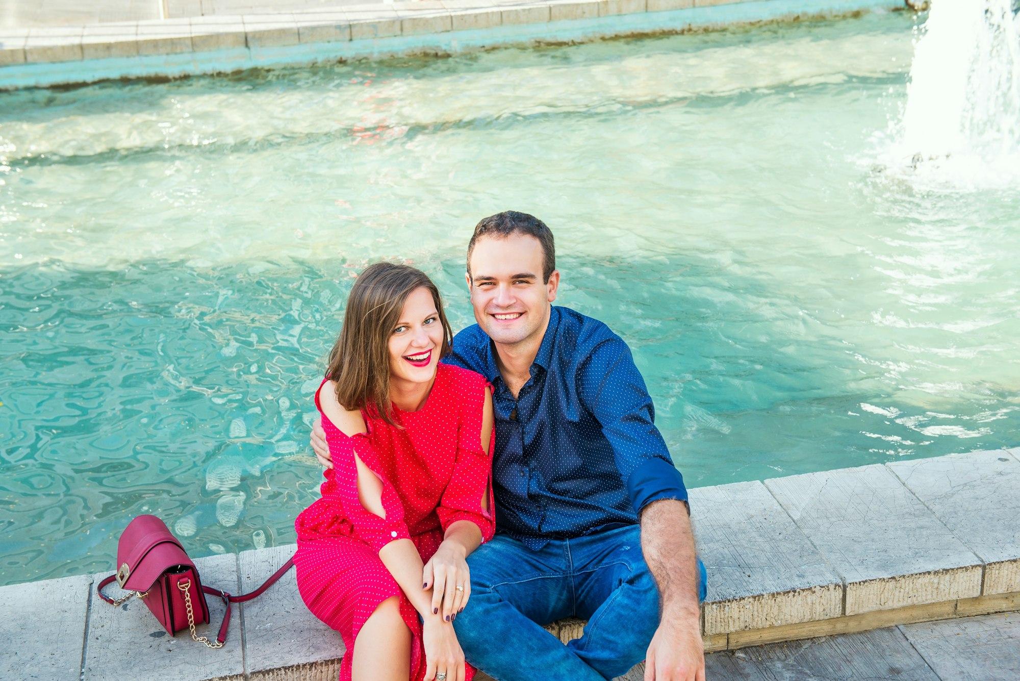 couple sitting near the city fountain and enjoying moments of happiness. Love, dating, romance