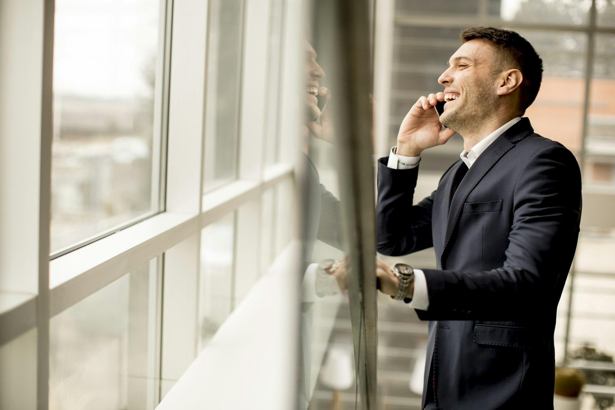 Handsome businessman in classic suit talking on mobile phone