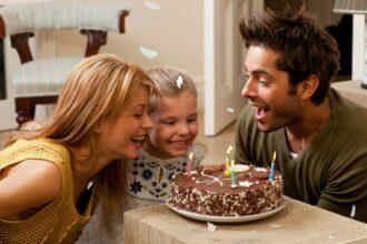 parents and child blowing out candles