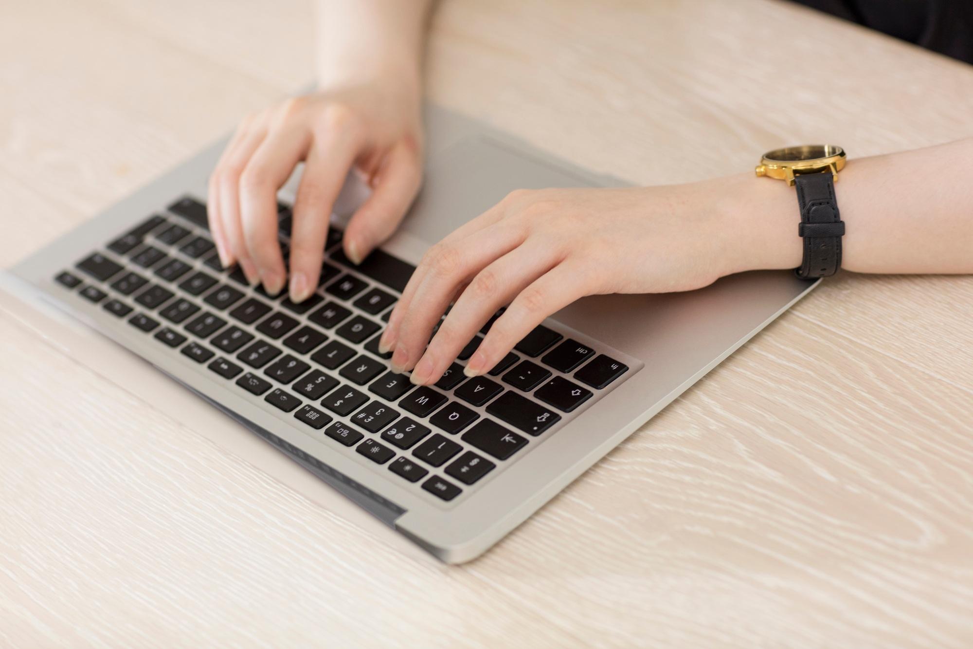 Woman typing on laptop keyboard