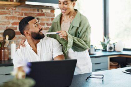 Couple, happy and surprise with pregnancy test in home with announcement, celebration and ivf succe