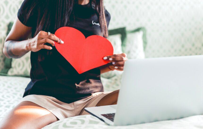 A woman chatting with her lover, holding a heart, love during COVID, long distance relationship