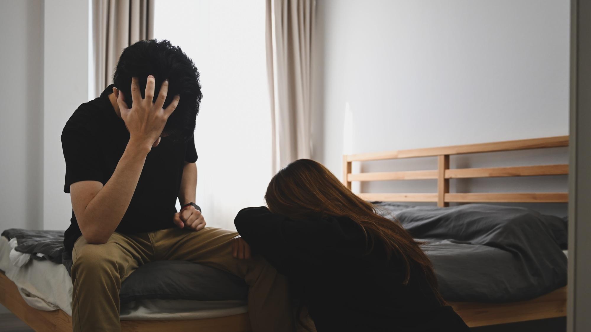 Unhappy couple having conflict while sitting in bedroom. Family relationships problems concept.