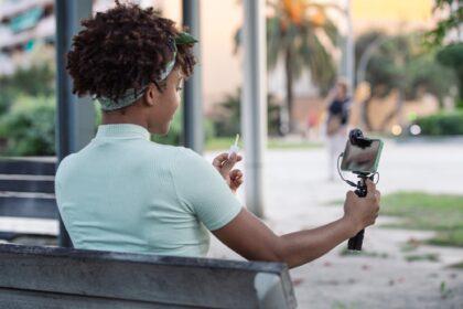 Afro young man streaming makeup tips for his followers on social media.