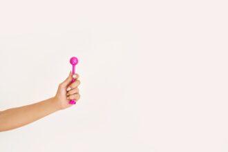 Young woman holding femine sex toys. Kegel adult exercise. Intimate gymnastics