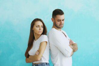 Couple standing back to back with arms crossed