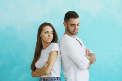 Couple standing back to back with arms crossed