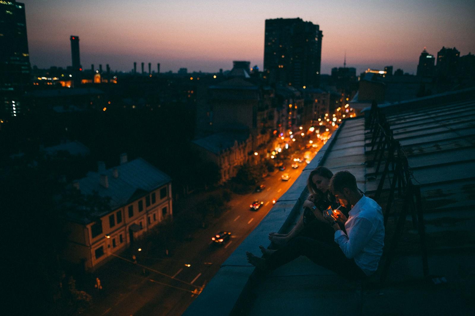 a couple of people sitting on top of a roof
