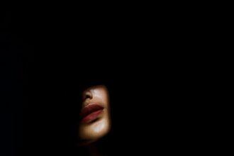 a woman's face in the dark with her eyes closed